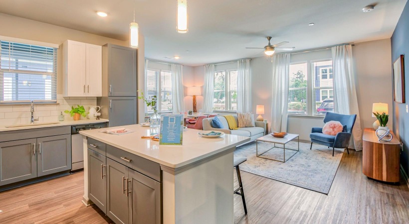 a kitchen island with barstools and a couch