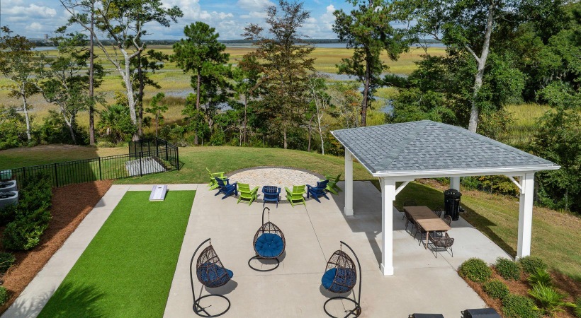 a patio with a gazebo and chairs and trees